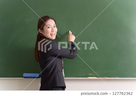 一位女老師在黑板前回頭看 127762362