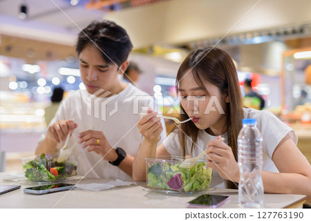 Young couple eating salad together 127763190