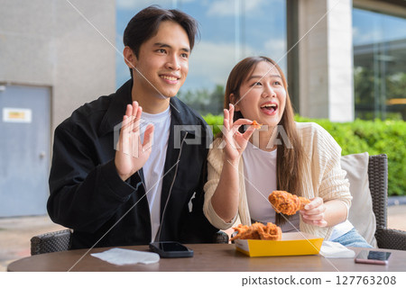 Young Asian couple eating fried chicken 127763208
