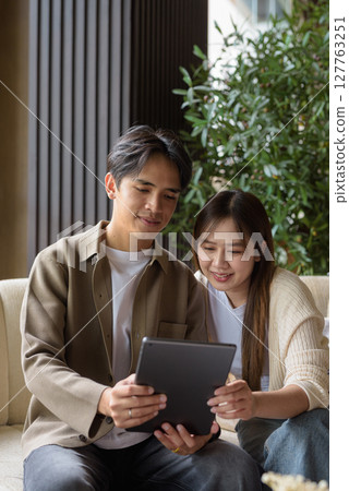 Couple using tablet computer in cafe while having coffee 127763251