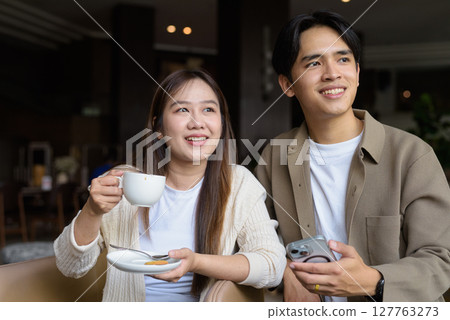 Young happy couple drinking coffee Young happy couple drinking coffee 127763273