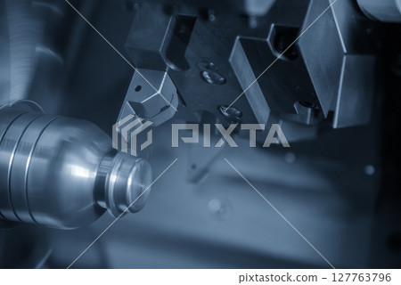 The CNC lathe machine groove cutting the metal mold parts in the light blue scene. The CNC lathe machine groove cutting the metal mold parts in the light blue scene. 127763796