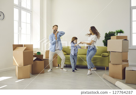 Happy family having fun in room with unpacked boxes in their new home on moving day Happy family having fun in room with unpacked boxes in their new home on moving day 127764287