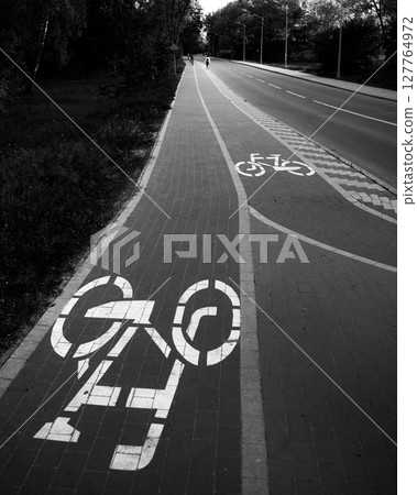 A bicycle path stretches into the distance, empty and serene in the early morning light A bicycle path stretches into the distance, empty and serene in the early morning light 127764972