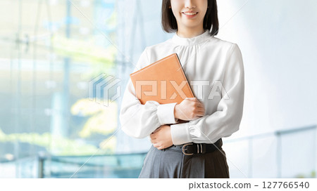 拿著活頁夾的微笑的婦女/女實業家 拿著活頁夾的微笑的婦女/女實業家 127766540