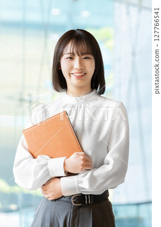 拿著活頁夾的微笑的婦女/女實業家 拿著活頁夾的微笑的婦女/女實業家 127766541