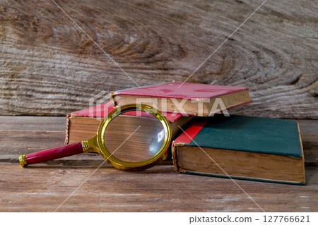 Vintage magnifying glass with old books. Concept for learn history. 127766621