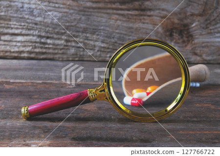Magnifying glass with pharmaceutical medicine pills, Magnifying glass with pharmaceutical medicine pills, 127766722