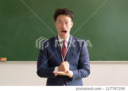 A male teacher has an idea in front of the blackboard A male teacher has an idea in front of the blackboard 127767200