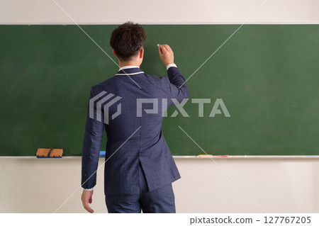一位男老師在黑板上寫字的背影 127767205