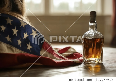 A bottle of whisky is on the table. USA flag A bottle of whisky is on the table. USA flag 127767692