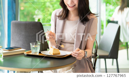 Woman eating cake at a cafe Woman eating cake at a cafe 127767965