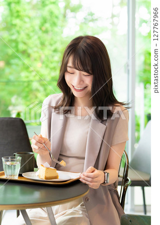 Woman eating cake at a cafe Woman eating cake at a cafe 127767966