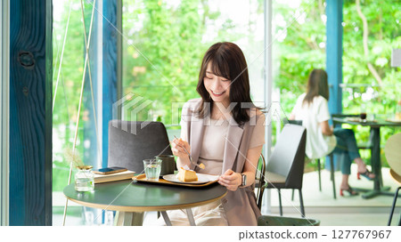 Woman eating cake at a cafe Woman eating cake at a cafe 127767967