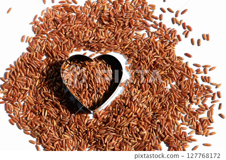 Heart-shaped on healthy uncooked raw red rice. Food for a healthy heart and blood vessels 127768172