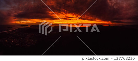 Panorama of sunrise or sunset with clouds and silhouette of coastline in Brazil 127768230