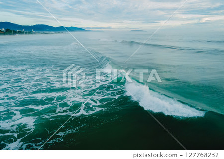 Ocean surf waves breacking in Brazil. Drone view of Campeche beach 127768232