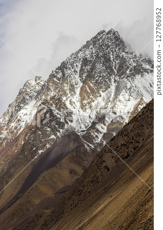 Majestic snow-covered Kyrgyzstan mountains in serene daytime setting 127768952