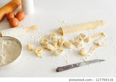 Ingredients and tools for making fresh homemade pasta on a floured surface. 127769116