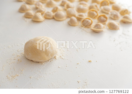 Raw homemade dumplings dusted with flour. Raw homemade dumplings dusted with flour. 127769122