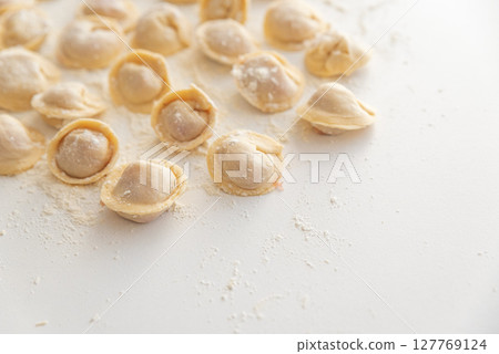 Raw homemade dumplings dusted with flour. 127769124