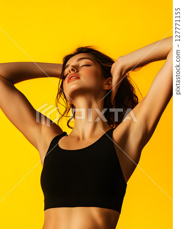 young athletic girl standing with hands folded above head on bright background. waist-up view young athletic girl standing with hands folded above head on bright background. waist-up view 127771155