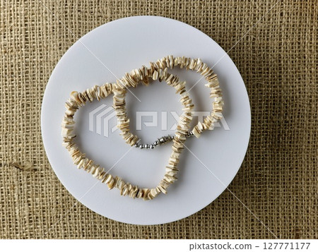 Handmade polished beige shell pieces necklace as a gift for a woman on a white background. Natural jewelry. Summer jewelry. 127771177