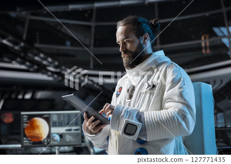 Cosmonaut in orbital station ensuring operational readiness before mission launch to Mars. Man working on spaceship doing Martian surface research to advance scientific knowledge Cosmonaut in orbital station ensuring operational readiness before mission launch to Mars. Man working on spaceship doing Martian surface research to advance scientific knowledge 127771435