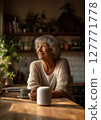 Senior woman smiling and sitting at kitchen table with smart speaker and cup of coffee in cozy home interior. Voice assistant device with artificial intelligence. Elderly and smart technology concept 127771778