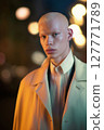 Stylish young man with platinum blonde hair wearing formal coat and shirt posing in evening city lights. Fashion portrait with soft bokeh background. Modern identity, gender expression, and beauty 127771789