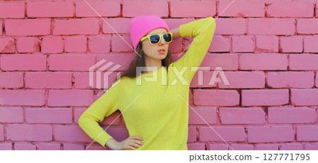 Portrait stylish young teenager girl in vivid colorful clothes, knitted yellow sweater and pink hat 127771795