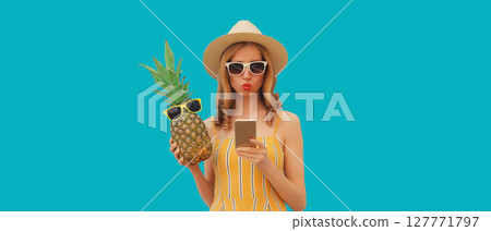 Summer portrait of happy young woman with phone holding fresh pineapple fruit in tourist hat Summer portrait of happy young woman with phone holding fresh pineapple fruit in tourist hat 127771797