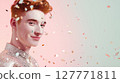 Stylish young man in sequin shirt smiling under falling confetti on pastel background. Studio portrait with soft lighting. Celebration, queer identity, and LGBT pride concept. Design for poster 127771811