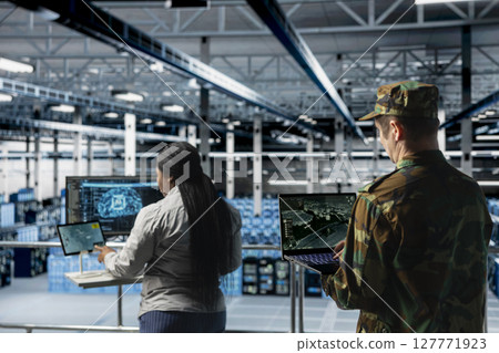Military units in server room flagging unusual movement using machine learning detection tools. Team of army specialist in data center mapping airborne activity using predictive AI software Military units in server room flagging unusual movement using machine learning detection tools. Team of army specialist in data center mapping airborne activity using predictive AI software 127771923