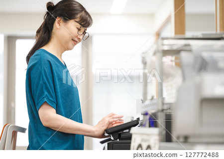 Woman making copies in the office 127772488