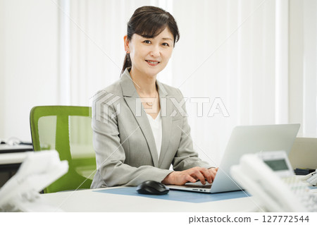 A career woman in her 50s doing desk work in a business office A career woman in her 50s doing desk work in a business office 127772544