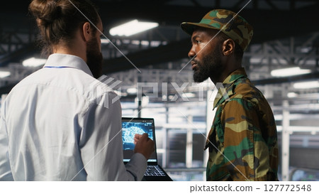 Army technicians in command center server room using artificial intelligence to detect cyber threats. Military data center experts use AI detection software to secure defense systems Army technicians in command center server room using artificial intelligence to detect cyber threats. Military data center experts use AI detection software to secure defense systems 127772548