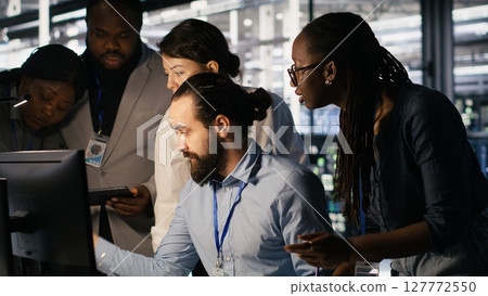 Admins doing brainstorming in server hub, reviewing machine learning code and LLM visualization dashboards. Data center IT experts using computer to monitor AI infrastructure performance, camera A 127772550