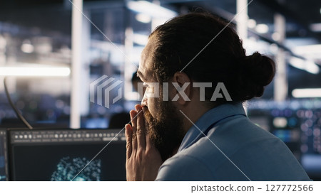 Exhausted computer scientist in server room reviewing neural network outputs, suffering from mental fatigue. Stressed data center IT expert analyzing AI LLM visualization, camera A 127772566