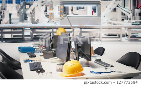 CAD program on PC monitor in photovoltaics factory used for production line design. Simulation software on computer screen in empty solar panels plant next to yellow hardhat Clean energy CAD program on PC monitor in photovoltaics factory used for production line design. Simulation software on computer screen in empty solar panels plant next to yellow hardhat Clean energy 127772584