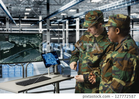 Military units in server room observing enemy activity with automated artificial intelligence tools. Team of army specialist in data center detecting flight paths using real time AI monitoring Military units in server room observing enemy activity with automated artificial intelligence tools. Team of army specialist in data center detecting flight paths using real time AI monitoring 127772587