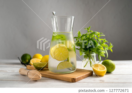 A glass jug with lemonade with lemons, limes and fresh mint, summer drink 127772671