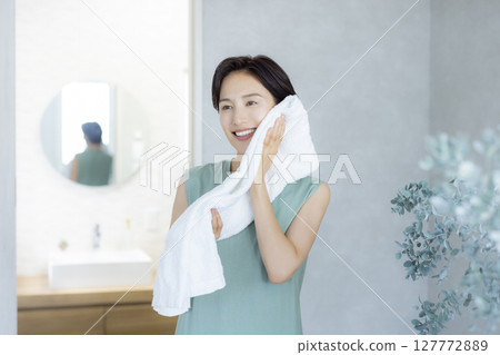 一位女士洗臉並用毛巾擦乾 一位女士洗臉並用毛巾擦乾 127772889