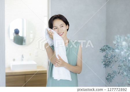 一位女士在臥室裡做皮膚護理 127772892