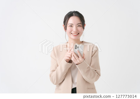 A woman with a suit with a smartphone A woman with a suit with a smartphone 127773014