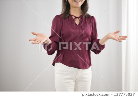 Middle-aged woman standing with hands outstretched 127773027