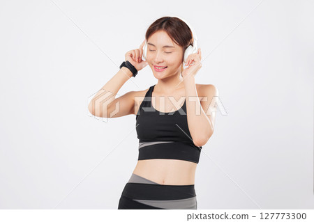 Dance to the beat with a fit Asian woman in sportswear enjoying music. Later, she breaks into a joyful dance, embracing fitness, lifestyle, and pure energy. isolated studio white background Dance to the beat with a fit Asian woman in sportswear enjoying music. Later, she breaks into a joyful dance, embracing fitness, lifestyle, and pure energy. isolated studio white background 127773300