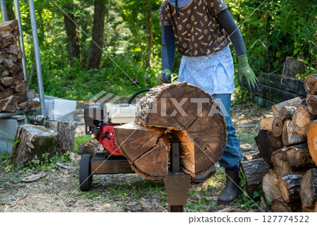 一名男子使用液壓劈木機劈柴 127774522