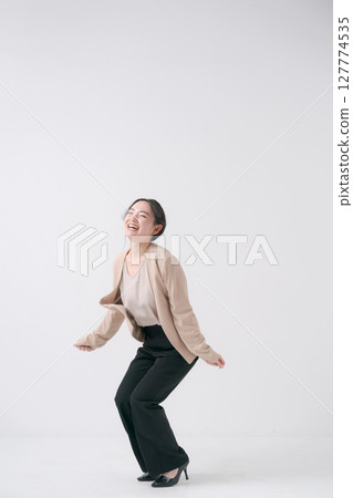 A woman in a suit jumping A woman in a suit jumping 127774535