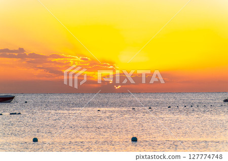 Beautiful yellow and orange sunrise over the sea. Beautiful yellow and orange sunrise over the sea. 127774748